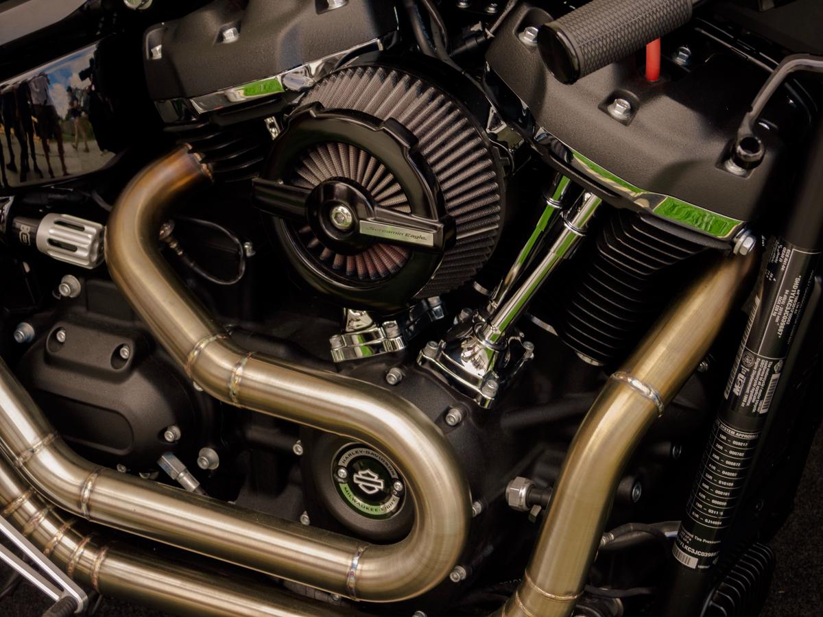 Motorcycle Vibration Issues: Causes & Fixes 4 Image depicting a person examining a motorcycle engine for vibrations